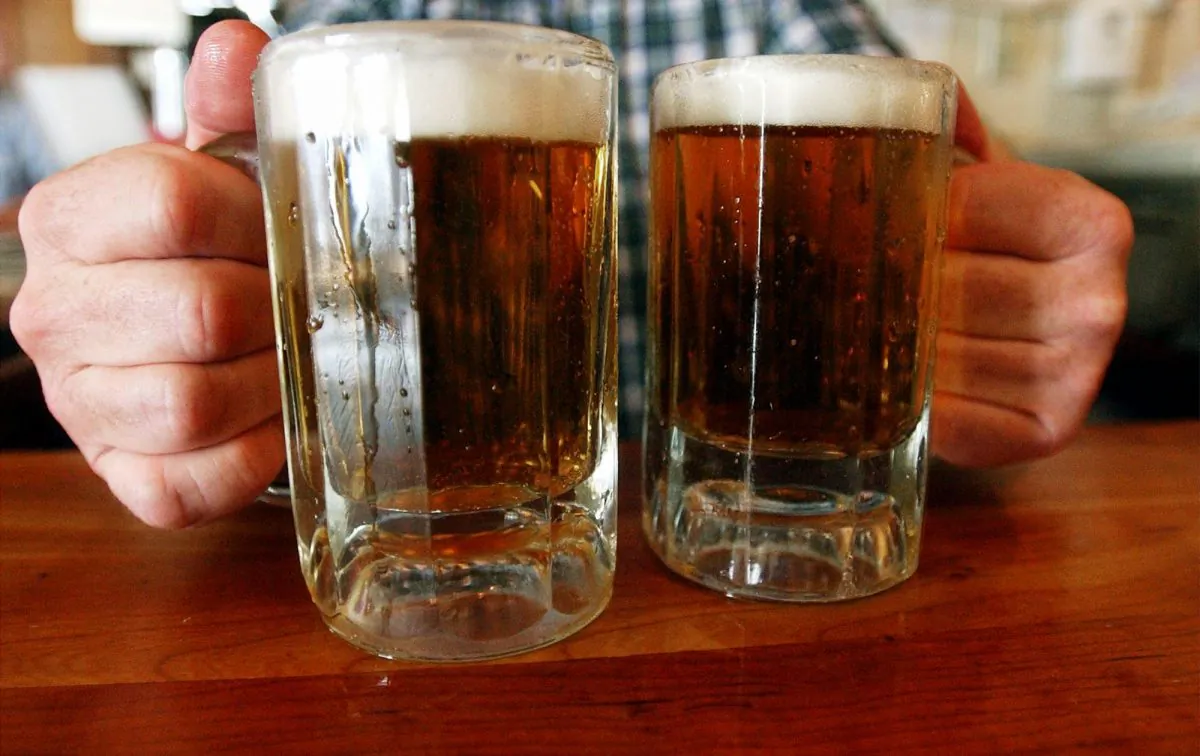 A bartender serves two mugs of beer at a tavern in Montpelier, Vermont, in this file photo. (AP Photo/Toby Talbot)