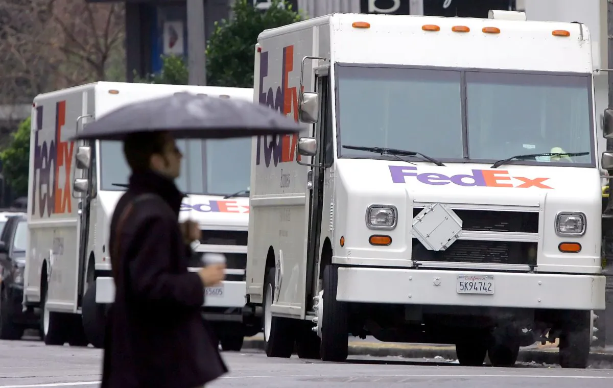 A man walks by two FedEx trucks in San Francisco, Calif., in this 2005 file photo. A explosion in the city's SOMA neighborhood was caused by firecrackers, police said after an investigation. (AP Photo/Jeff Chiu)