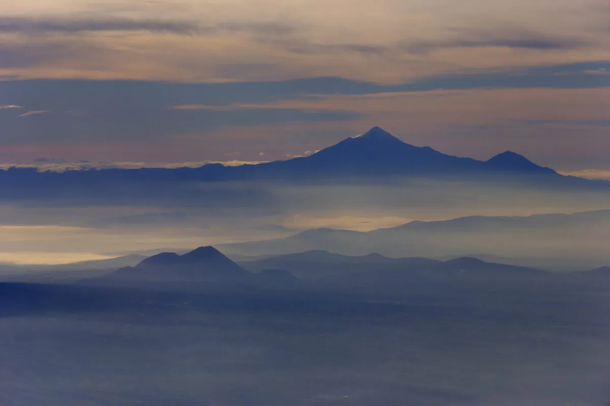 Mexico's highest peak and the third highest in North America, Pico de Orizaba, or Citlaltepetl mountain, rises above the morning mist as seen from a Mexican Navy aircraft on a volcano monitoring mission in Mexico on July 23, 2013. (Dario Lopez-Mills/AP Photo)