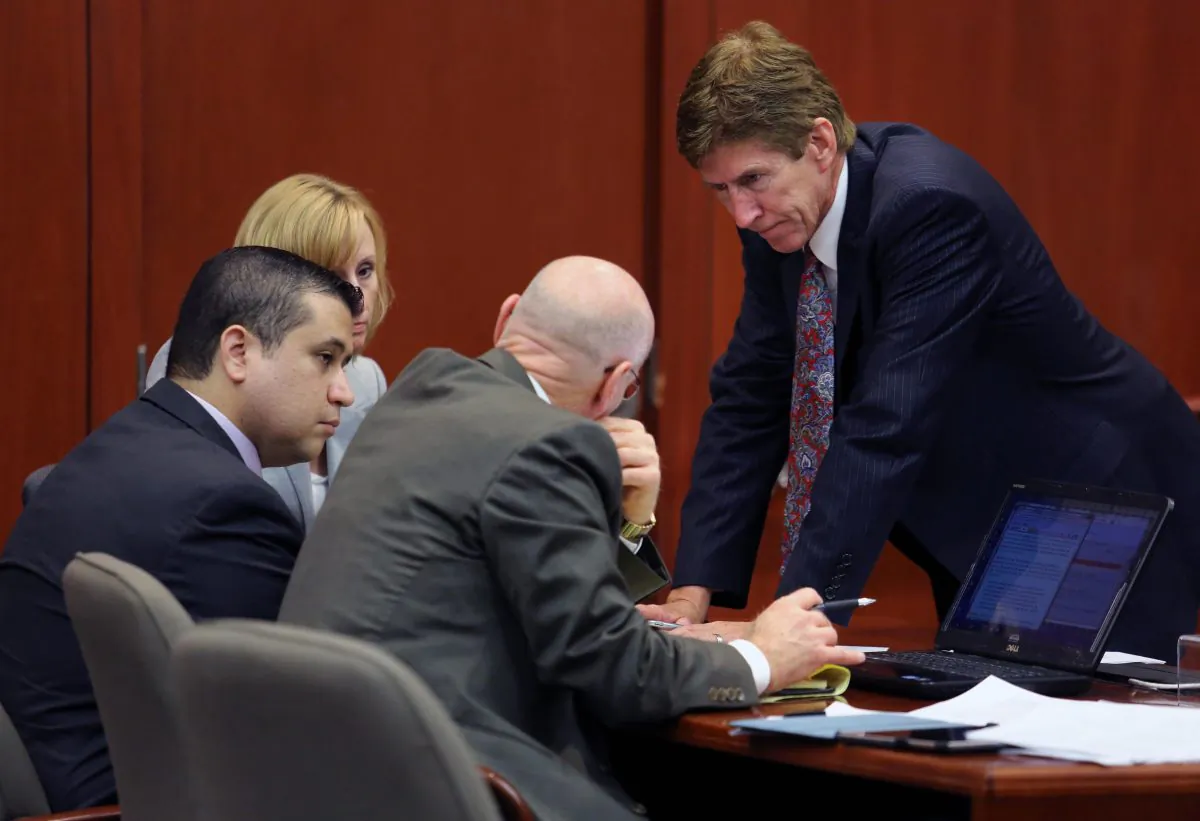 George Zimmerman, left, confers with his defense counsel, Mark O'Mara, Don West, and Lorna Truett, background. O'Mara said after the not guilty verdict that Zimmerman wouldn't have been charged in the 2012 shooting death of Trayvon Martin if he were black. (AP Photo/Orlando Sentinel, Joe Burbank, Pool)