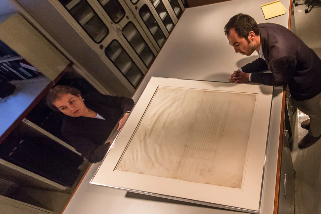 Evelyn Frangakis, Assistant Director for Preservation at The New York Public Library (NYPL), stands next to the Bill of Rights with NYPL curator William Stingone. The Bill of Rights and the Declaration of Independence are on exhibit in New York City through July 3. (Jonathan Blanc/The New York Public Library)