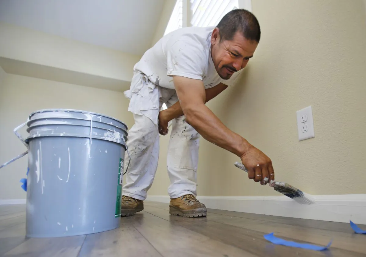 Painter Salvador Escoto paints the baseboard of a house under construction in Sacramento, Calif., Friday June 21, 2013. (AP/Rich Pedroncelli)