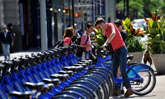 A couple get their Citi Bike bicycles from a station near Union Square as the bike sharing system is launched May 27 in New York. (STAN HONDA/AFP/Getty Images)
