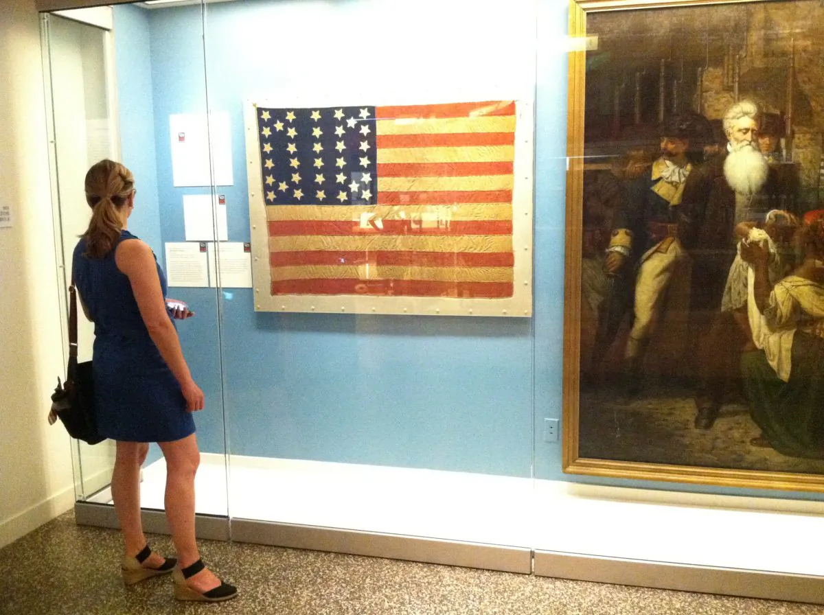 A woman stands in front on an 1861 American flag with 34 stars on it at the New York Historical Society Museum and Library in Manhattan on July 4. The museum hosted a day of educational exhibits, activities and performances throughout the day. 