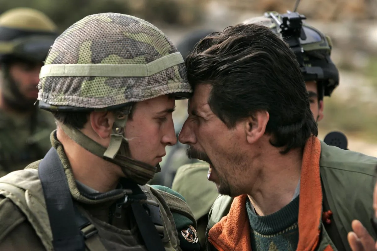 A Palestinian man argues with an Israeli soldier during a demonstration against Israel's separation barrier at the village of Bilin, near the West Bank city of Ramallah, on Dec. 14, 2007. The United States on Sunday, July 28, 2013, announced the resumption of Israeli-Palestinian talks following years of stalemate. (AP Photo/Sebastian Scheiner, File)