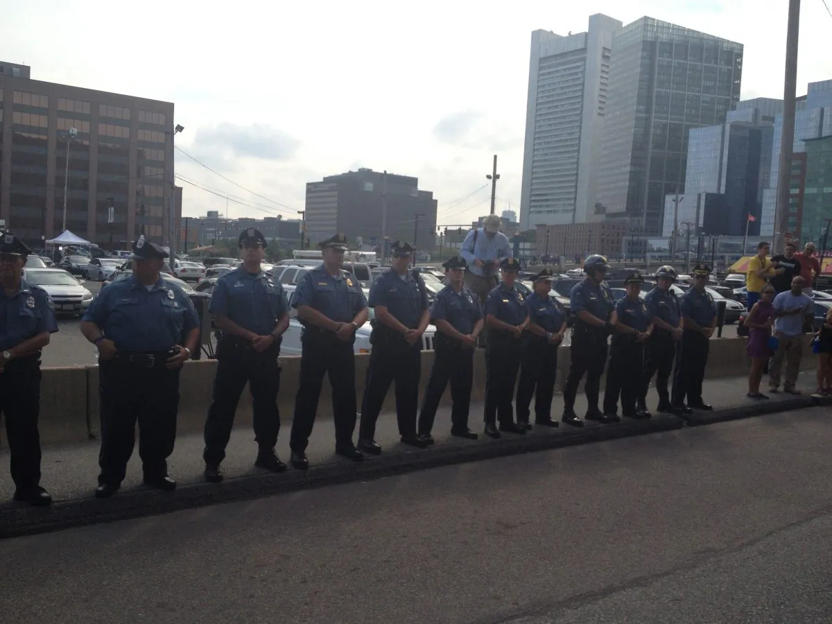MIT Police officers stand at attention across the street from the Moakley Federal Courthouse in Boston Mass., during Dzhokhar Tsarnaev arraignment on July 10, in honor of Officer Sean Collier who was killed in the aftermath of the Boston Marathon Bombings. (Phoebe Ryles/Epoch Times)