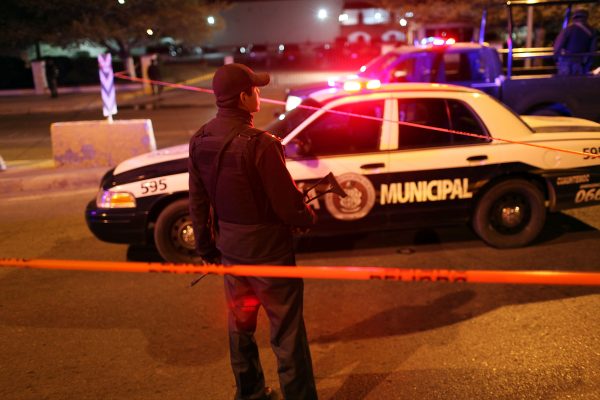 In this file photo, Mexican police gather at an early morning murder, one of numerous murders over a 24 hour period, on March 26, 2010 in Juarez, Mexico. Violent clashes between police and gunmen from drug cartels claimed 22 lives Tuesday across Mexico’s Michoacan state. (Spencer Platt/Getty Images)