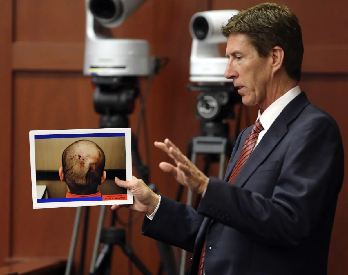 Defense attorney Mark O'Mara displays photos of George Zimmerman, taken the night of the shooting of Trayvon Martin, during cross examination of Jacksonville medical examiner Valerie Rao during Zimmerman's trial in Seminole circuit court, in Sanford, Fla., Tuesday, July 2, 2013. Zimmerman is charged with second-degree murder in the shooting death of Trayvon Martin. (AP Photo/Orlando Sentinel, Joe Burbank, Pool)