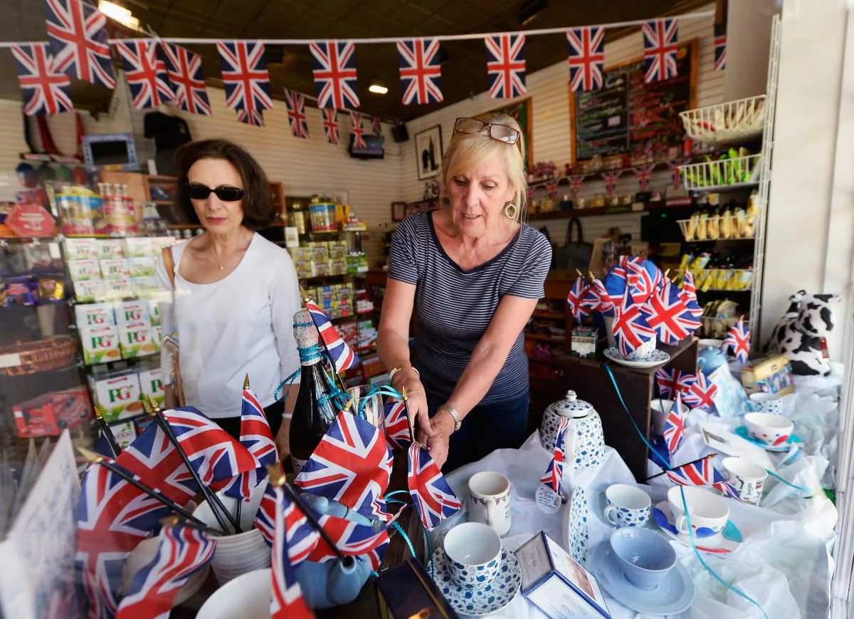 Linda Roberts (R) dresses her window at Ye Olde King's Head English pub's gift shop in Santa Monica, Calif., on July 22, 2013, with flags and baby blue colors to celebrate the announcement of the birth of Catherine, Duchess of Cambridge, and her husband Prince William's first child. (Kevork Djansezian/Getty Images)