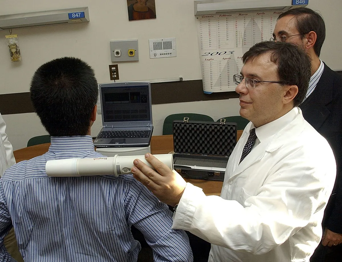 Gianpiero Lorandi, head of the mission and support systems product line of Galileo Avionica, demonstrates the use of a Trimprob non-invasive cancer detection tool on July 21, 2003. The tool's creator, Clarbruno Vedruccio, recently signed an agreement with Emergency Solutions to bring the tool to hospitals. (Alex Wong/Getty Images) 