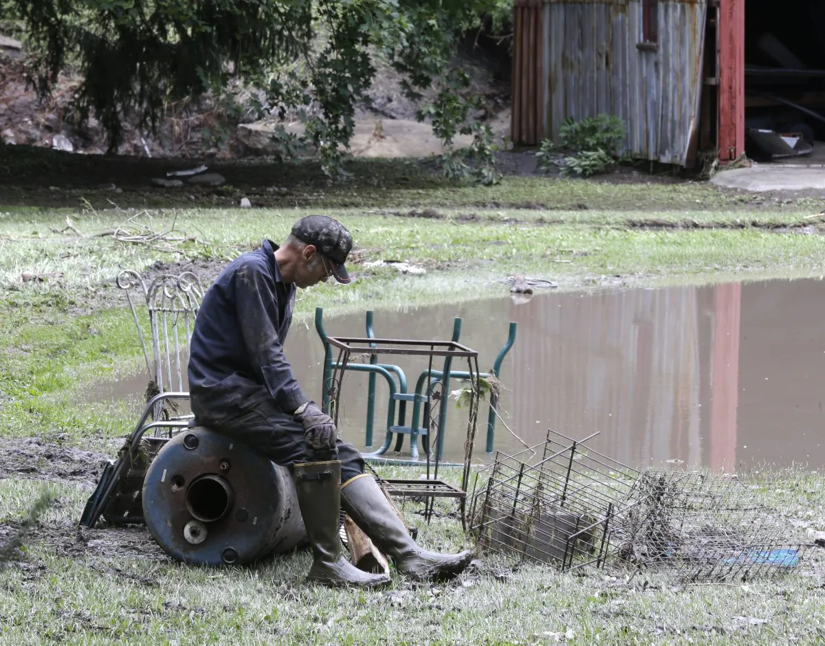 Greg Erhardt takes a break from salvaging items after flooding on June 28, in Fort Plain, N.Y. Gov. Andrew Cuomo is asking President Barack Obama to declare a major disaster caused by severe flooding in New York. (AP Photo/Mike Groll)
