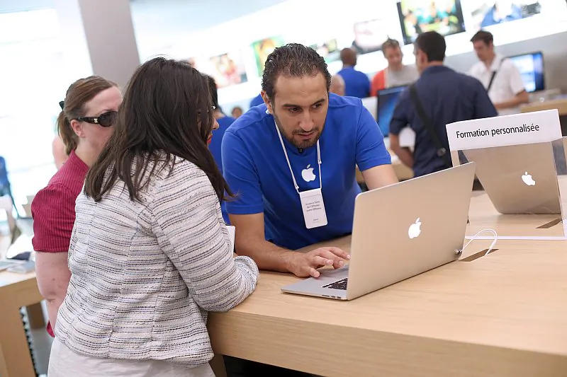 An employee demonstrates Apple’s MacBook Pro laptop to a customer in an Apple store in Rosny-sous-Bois, near Paris, France, July 6. (Thomas Samson/AFP/Getty Images)
