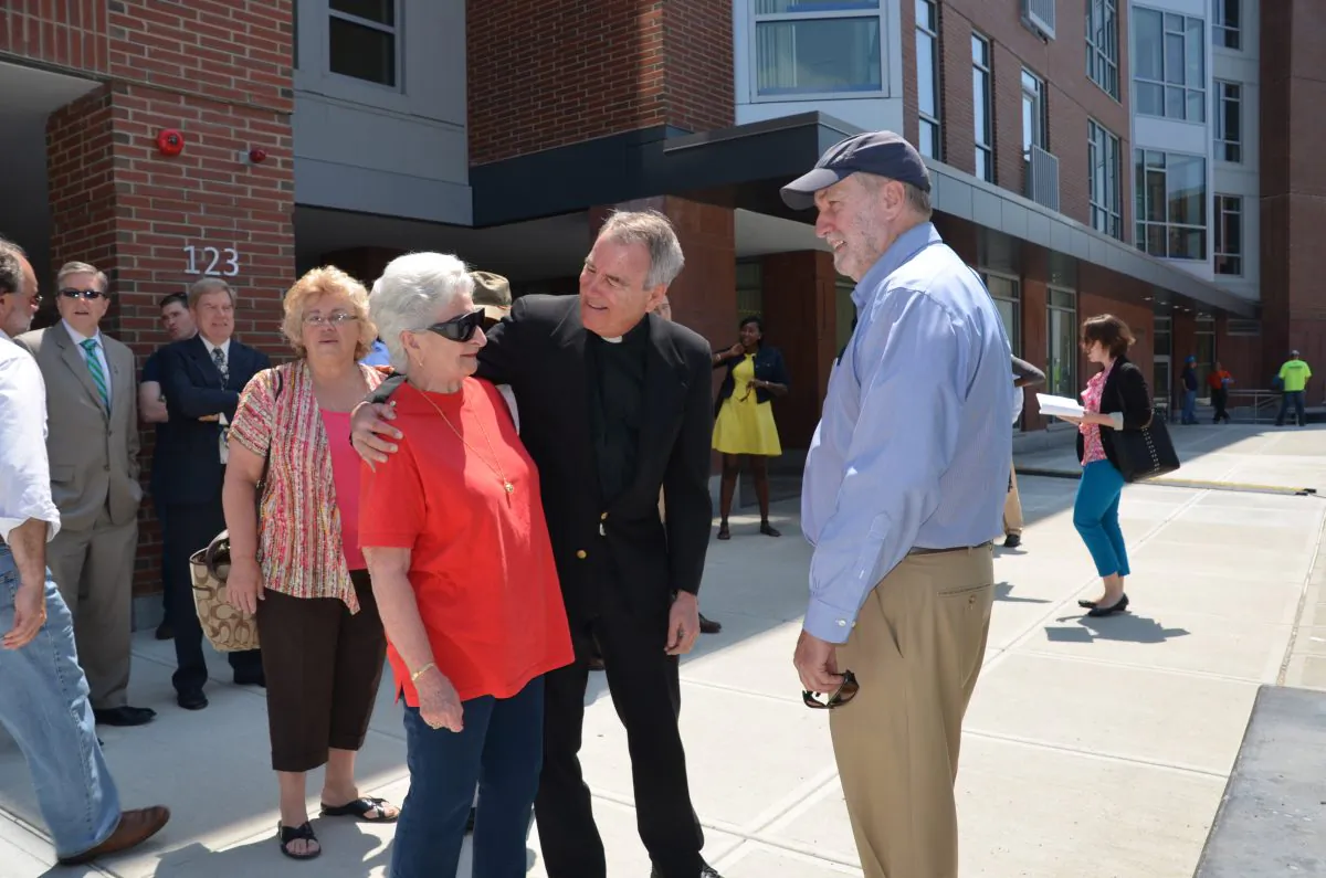Father Frank Glynn talks with residents at the opening of the Josephine A. Fiorentino Community Center at the Charlesview Residences in Boston, Mass. Creating a community was a central part of development plan for this affordable housing complex. (Deborah Addis, Addis Communications)