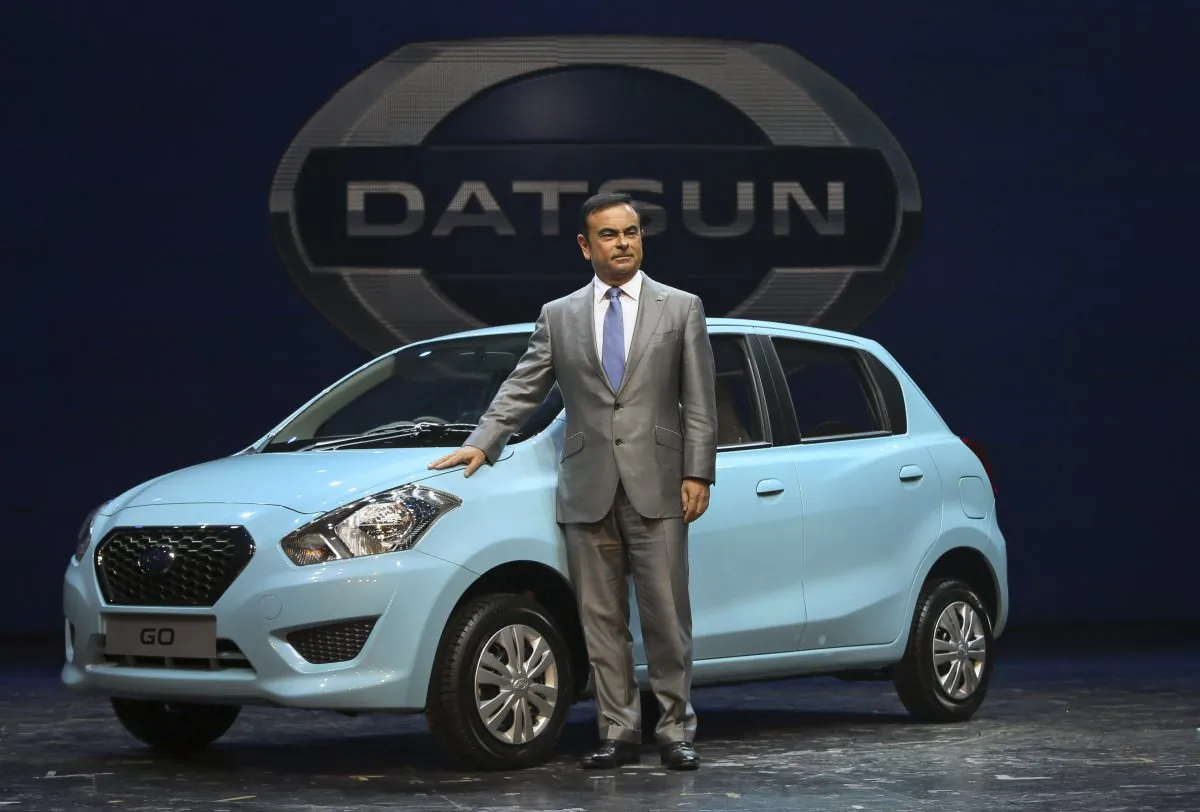 Nissan Motor Co. President and CEO Carlos Ghosn poses for the media with Datsun Go during its global launch in New Delhi, India, Monday, July 15, 2013. Nissan has introduced the first new Datsun model in more than three decades in the Indian capital. The company hopes bringing back the brand that built its U.S. business will fuel growth in emerging markets with a new generation of car buyers. The reimagined Datsun - a five-seat hatchback - will go on sale in India next year for under 400,000 rupees (about $6,670). (AP Photo/Manish Swarup)