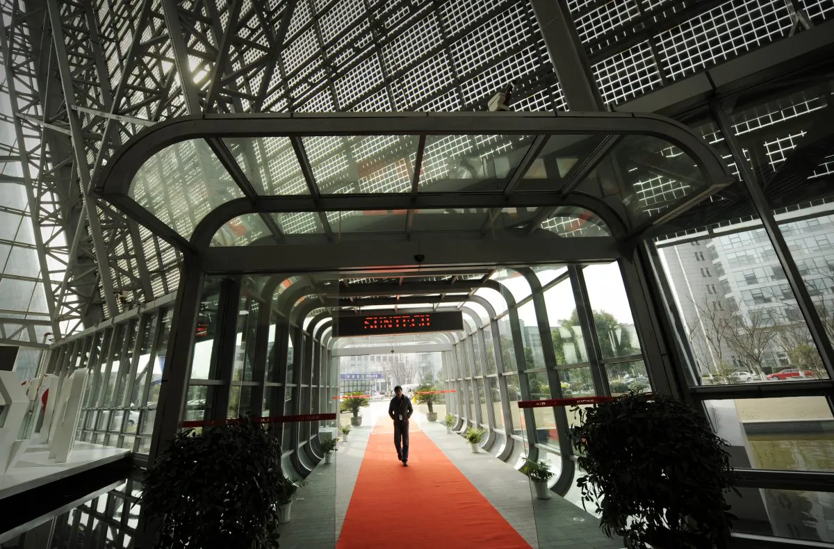 A visitor enters the offices of the now bankrupt Chinese company Suntech in the eastern Chinese city of Wuxi, Feb. 27, 2012. One of its subsidiaries filed for bankruptcy earlier this year, highlighting the perils now facing many industries that accumulated overcapacity over years of artificially cheap financing. (Peter Parks/AFP/Getty Images)