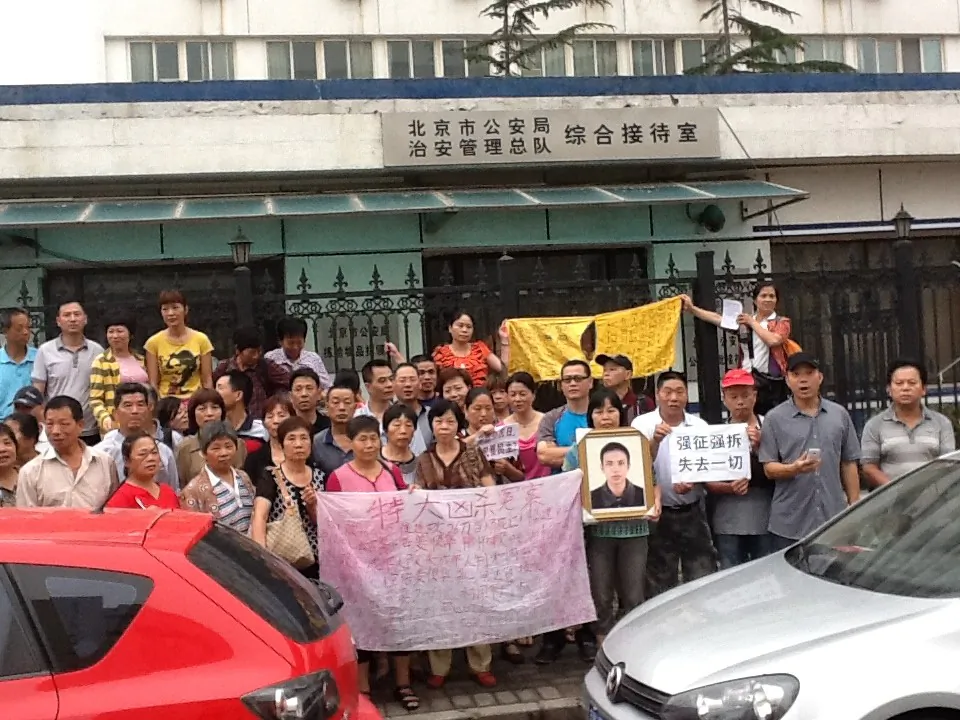 Petitioners from across China stand outside a building affiliated with the Beijing Public Security Bureau on July 1, the 92nd anniversary of the founding of the Chinese Communist Party. They held signs and shouted out slogans like "Down with corrupt officials." (Human Rights Campaign in China)