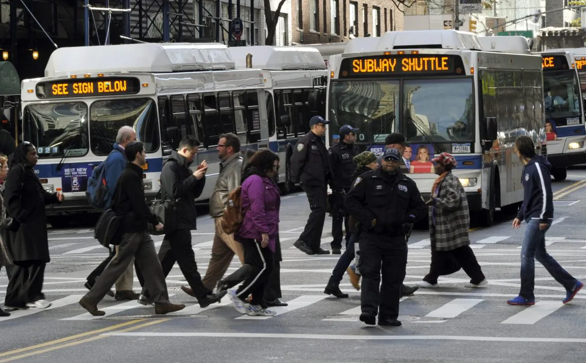A traffic officer directs people to MTA buses used for subway shuttles on 57th street on November 1, 2012 in New York City. (TIMOTHY A. CLARY/AFP/Getty Images)