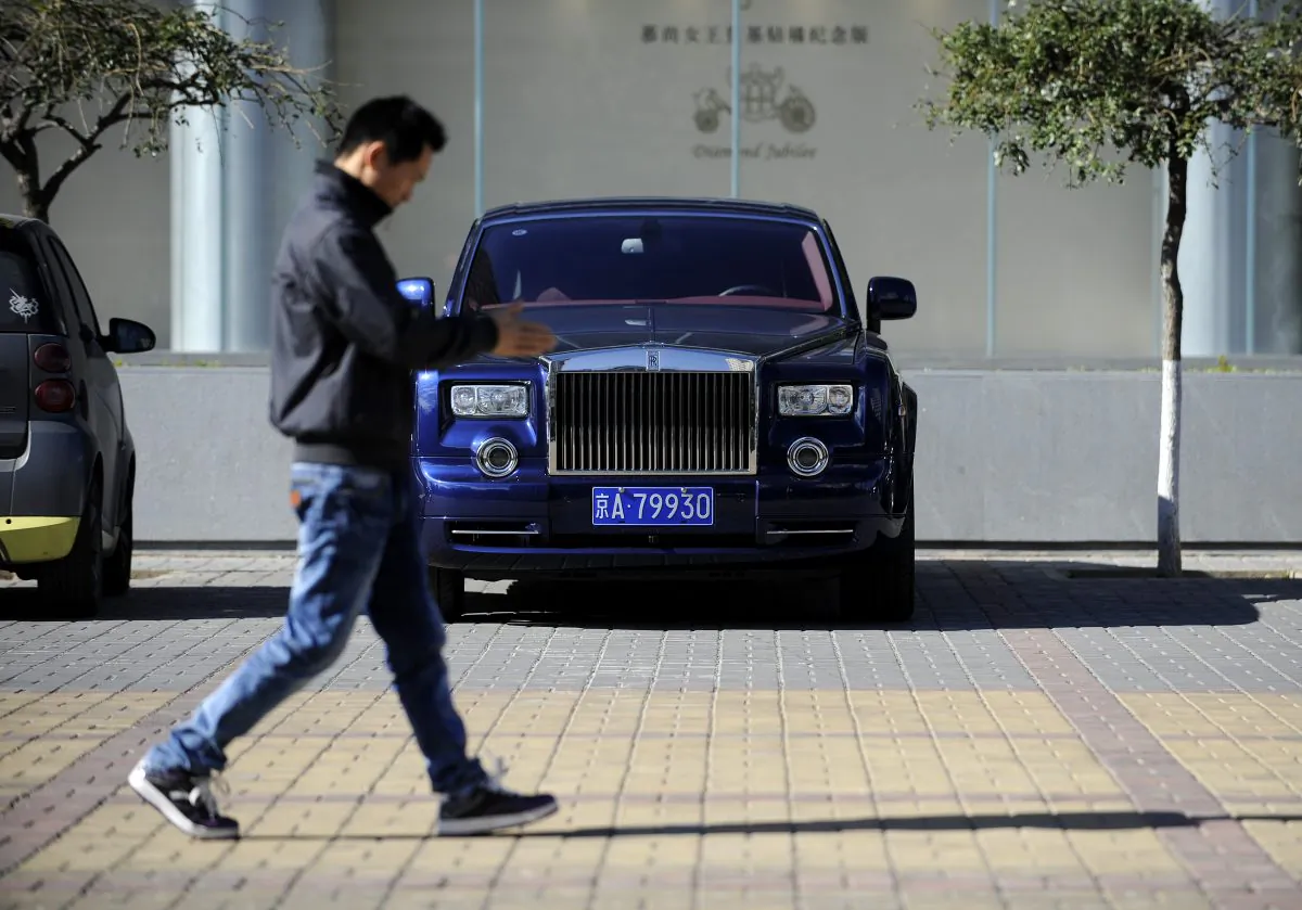 This picture taken on Oct. 31, 2012, a Chinese man walks past a Rolls-Royce outside an auto shop in Beijing. Only a quarter of wealthy Chinese are very confident in the Chinese economy. (Wang Zhao/AFP/Getty Images)