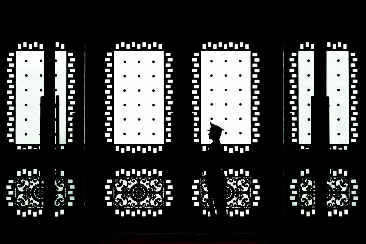 A Chinese soldier stands guard at the main entrance door of the Bayi building in Beijing on April 23, 2013. The Chinese regime runs networks of military hackers who target U.S. businesses and government offices. (Andy Wong/Getty Images)
