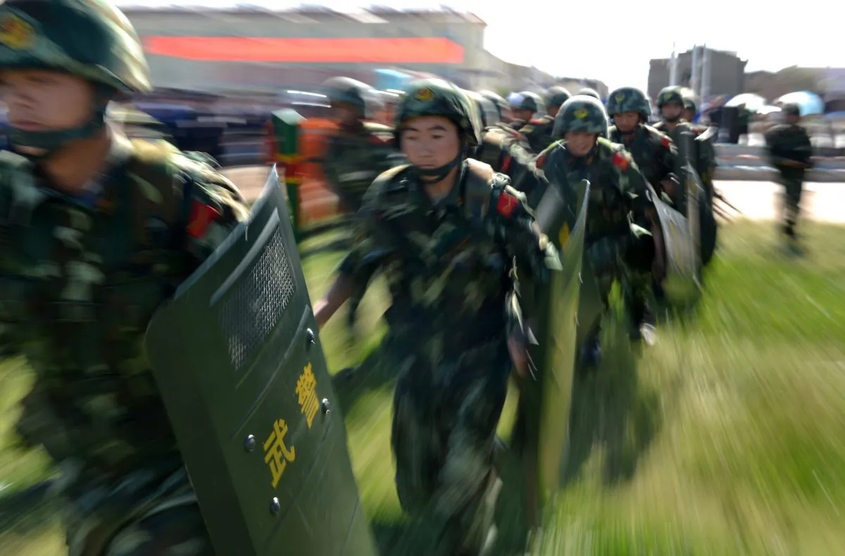 An anti-terrorism force including public security police and the armed police attend an anti-terrorism joint exercise in Hami, northwest China's Xinjiang region on July 2, 2013. At least 15 Uyghurs were killed in an “anti-terrorist” raid on Aug. 20 in Kashgar Prefecture. (STR/AFP/Getty Images)
