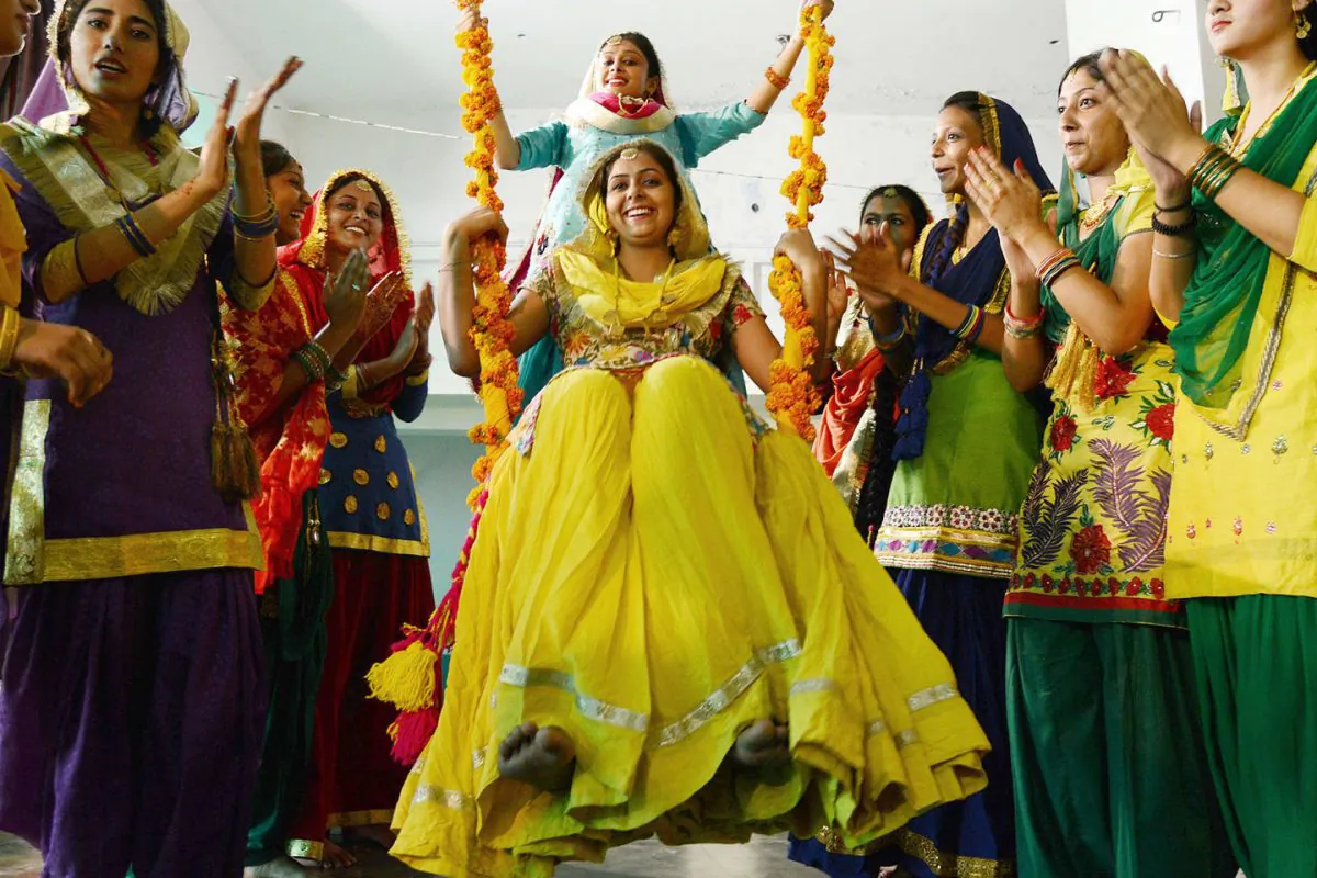 Indian college girls wear traditional Punjabi dress sit on a swing during Teej festival celebrations on the occasion of Sawan (rain) Month at Khalsa college for women in Amritsar on August 3, 2013.  The Teej festival heralds the rainy season and is especially popular with women and revolves around dressing in finery and singing and dancing. (Narinder Nanu/AFP/Getty Images)