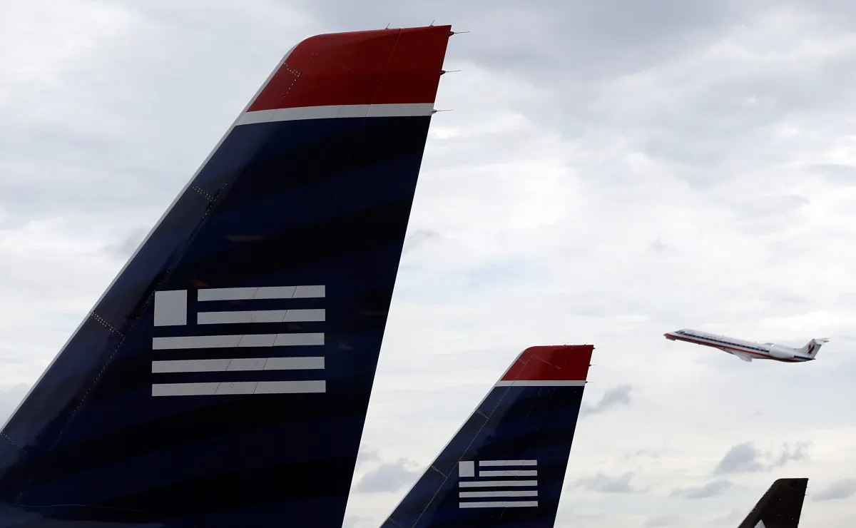 An American Airlines jet takes off behind US Airways jets at Ronald Reagan Washington National Airport in Arlington, Va., Aug. 13, 2013. The Department of Justice filed an antitrust lawsuit Tuesday to block the planned merger of US Airways and American Airlines. (Win McNamee/Getty Images)