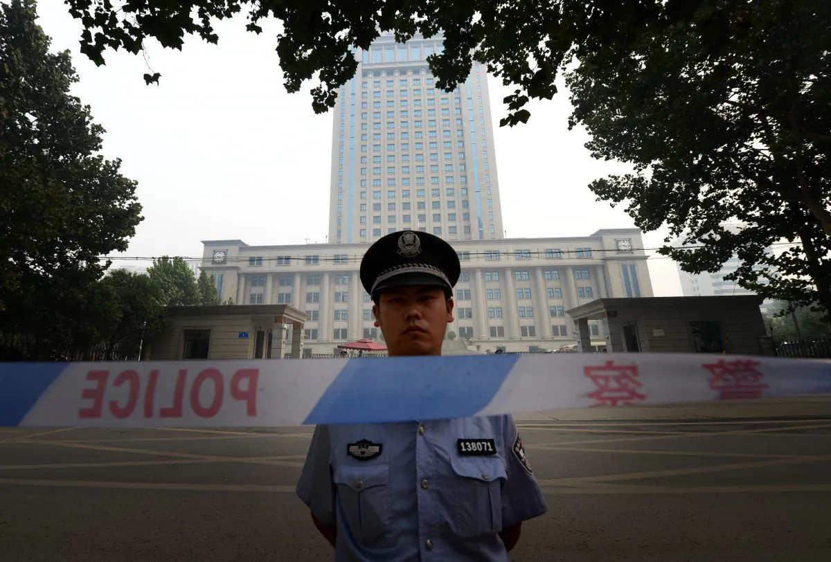 A police officer stands guard at the Intermediate People's Court in Jinan, Shandong Province, China, on Aug. 24, 2013. (Mark Ralston/AFP/Getty Images)