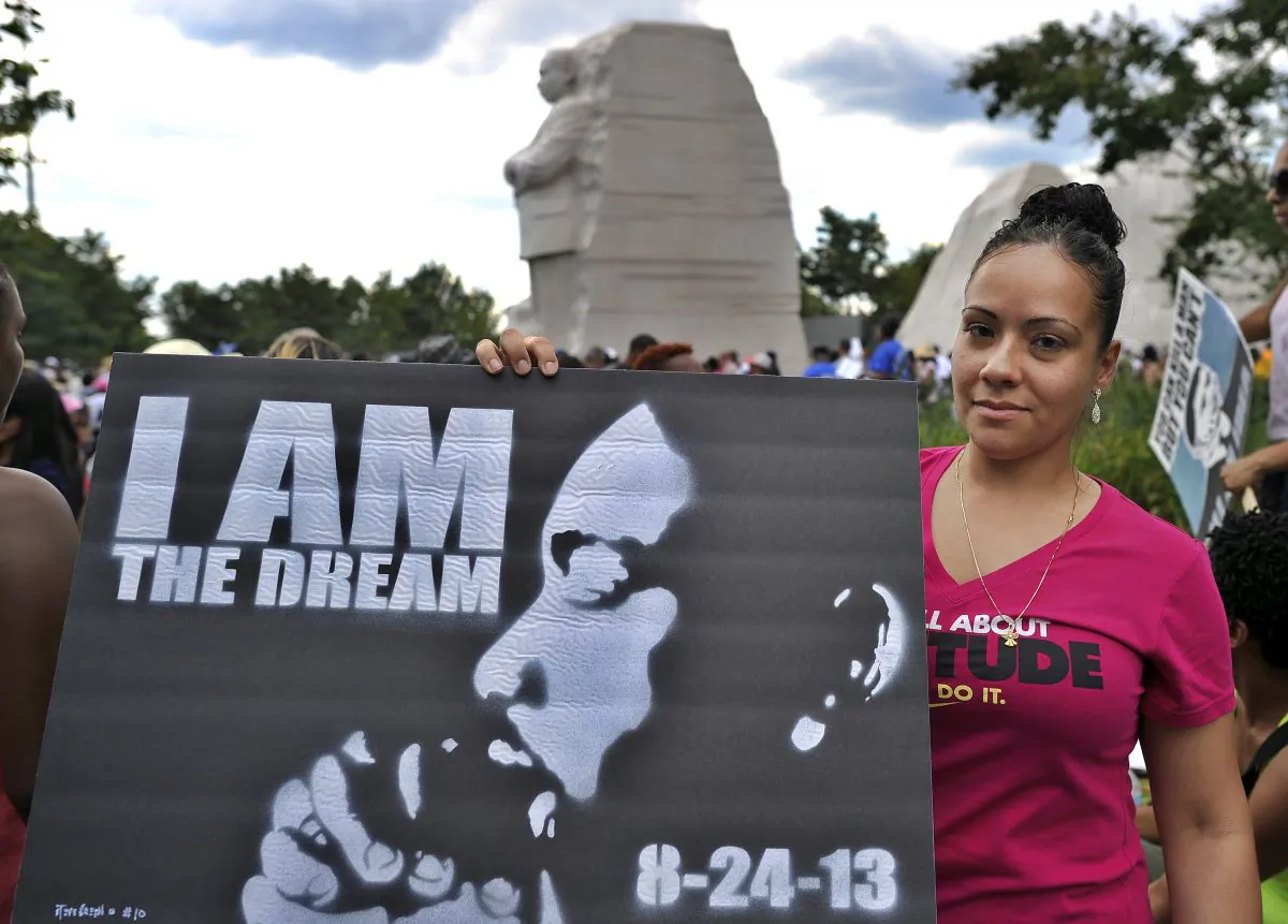 A woman displays a placard at Martin Luther King Jr. memorial on August 24, in Washington, DC, to commemorate the 50th anniversary of The March on Washington. (Jewel Samad/AFP/Getty Images)