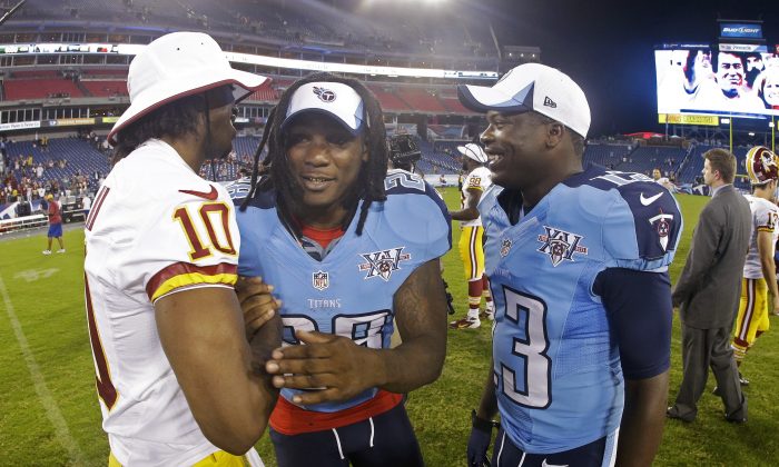 Tennessee Titans running back Chris Johnson (28) and wide receiver Kendall Wright (13) talk with Washington Redskins quarterback Robert Griffin III (10) after a preseason NFL football game Thursday, Aug. 8, 2013, in Nashville, Tenn. The Redskins won 22-21. (AP Photo/Wade Payne)