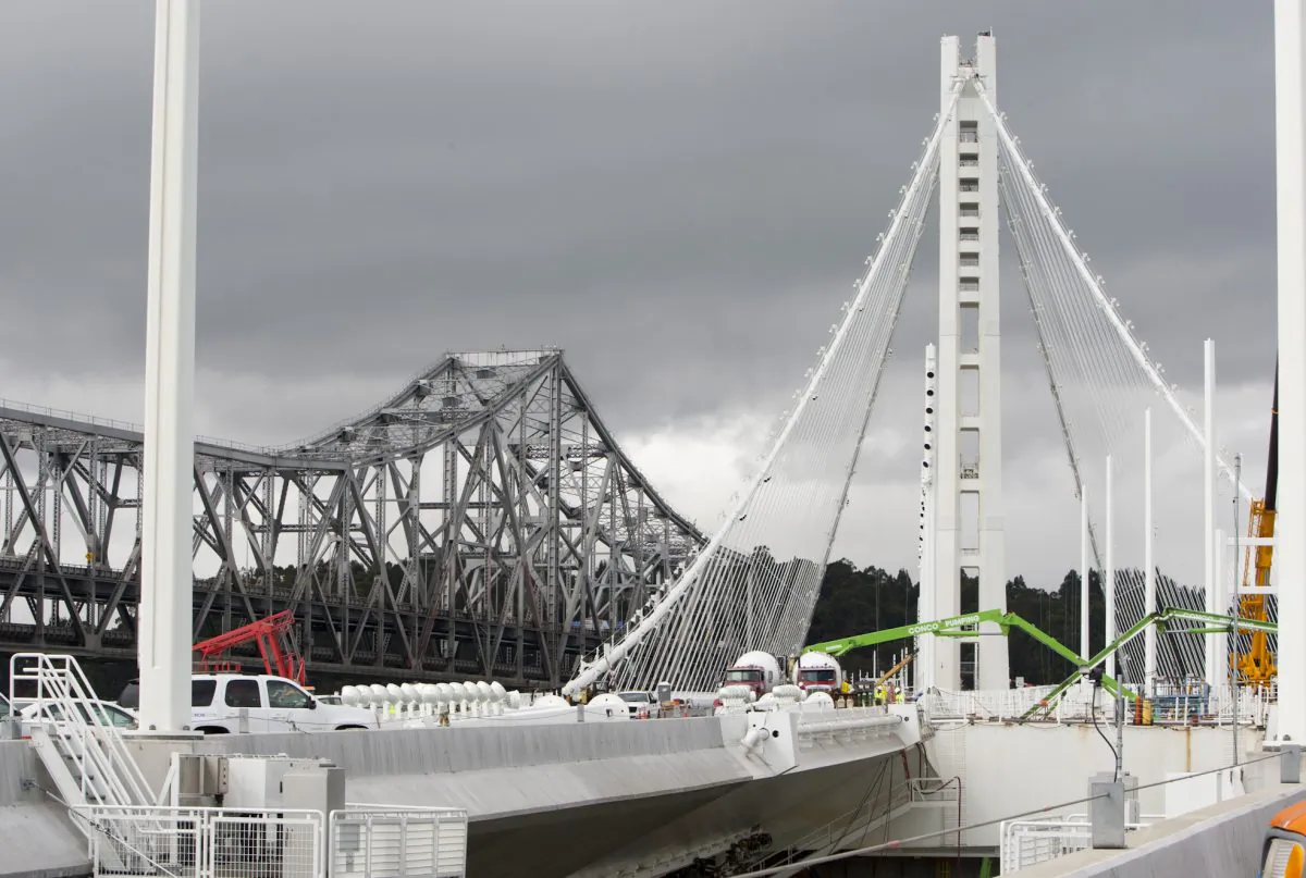 The new eastern span of the San Francisco–Oakland Bay Bridge under construction, with the old span in the background (L) in Oakland, Calif., Aug. 8, 2013.
(Alex Ma/Epoch Times)
