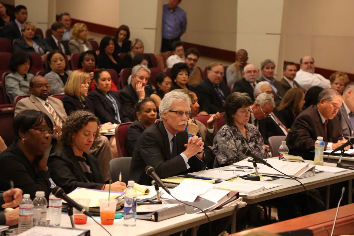 Vin Harrington, union counsel, speaks on behalf of SEIU Local 1021 BART workers, while SEIU President Roxanne Sanchez (2nd R) look on, at a public hearing on the BART labor dispute in Oakland, Calif., Aug. 7, 2013.
