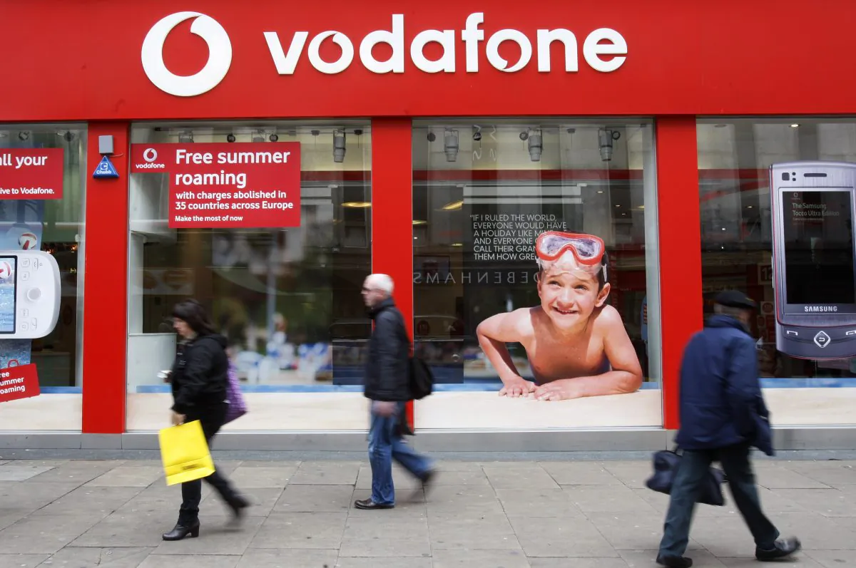 People walk by a branch of Vodafone in central London is seen in a 2009.(AP Photo/Sang Tan, File)