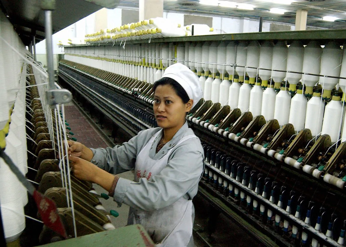 A Chinese worker going about her chores at a factory manufacturing textiles for export in Haikou, on the southern Chinese island of Hainan, on March 30, 2004. Current data and anecdotes indicate that foreign manufacturers are seeking cheaper places of production than China. (AFP/Getty Images)