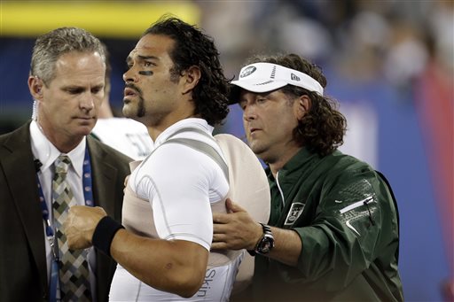 A trainer wraps New York Jets quarterback Mark Sanchez, center, during the second half of a preseason NFL football game against the New York Giants, Saturday, Aug. 24, 2013, in East Rutherford, N.J. (AP Photo/Julio Cortez)