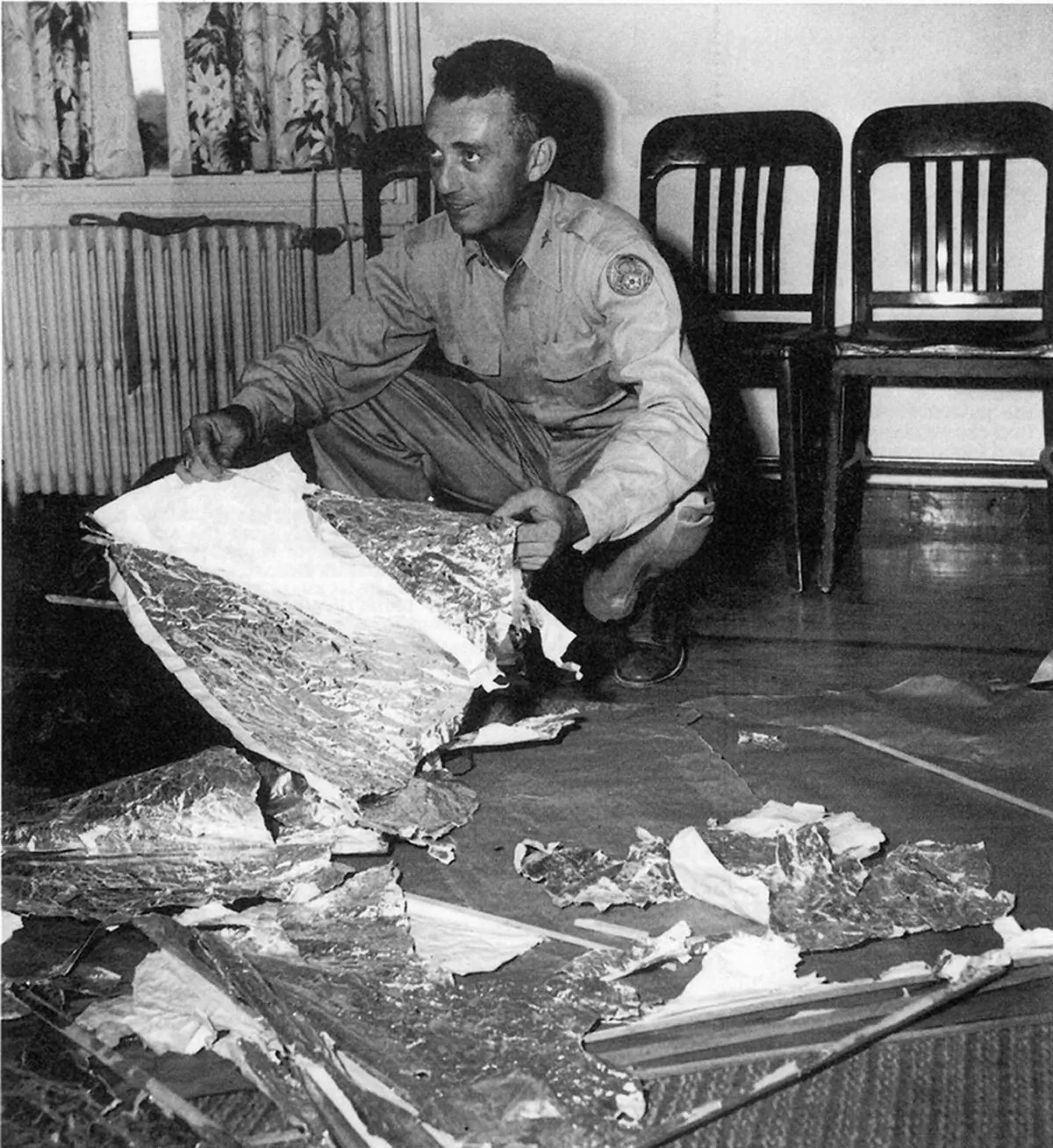 Maj. Jesse Marcel from the Roswell Army Air Field with debris found 75 miles north west of Roswell, N.M., in June 1947. The debris has been identified as that of a radar target. The Air Force released a report on June 24 debunking reports of a UFO crash near Roswell, N.M., in 1947. (UNITED STATES AIR FORCE/AFP/Getty Images)