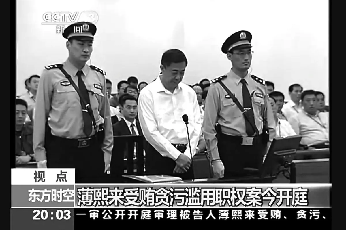Former Politburo member Bo Xilai stands between two guards at the Jinan Intermediate Court in Shandong Province for the first day of his trial on Aug. 22. Bo's trial was negotiated to be depoliticized, according to experts. 
 A prosecutor urged a Chinese court to punish disgraced politician Bo with a severe sentence because of his lack of remorse over alleged corruption and abuse of power, in a trial that has offered a glimpse into the shady inner workings of China's elite. (Screenshot/Epoch Times) 
