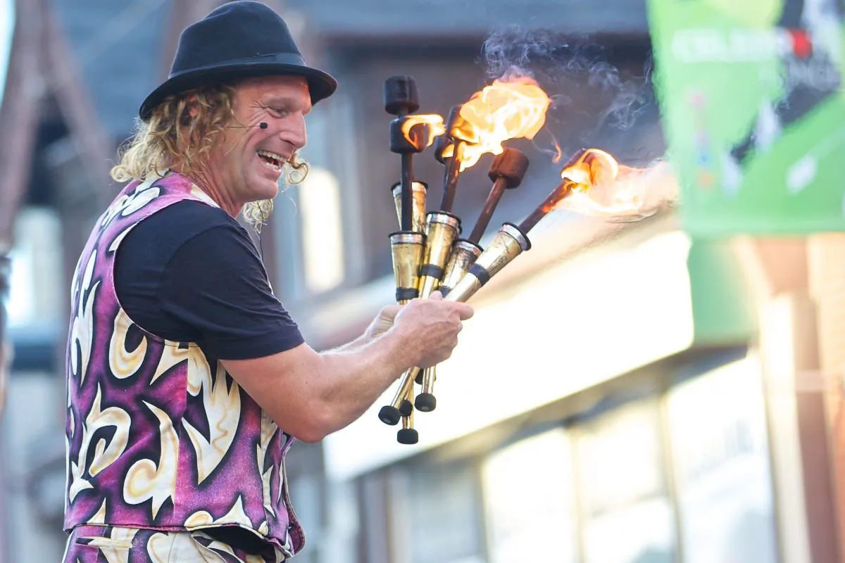 A performer invites onlookers to a playful fire display at BuskerFest. (Quincy Clark/DQC Photo)