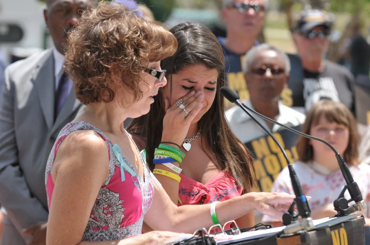Jane Dougherty (L) and Carlee Soto read the names of victims at a remembrance ceremony in Aurora, Colo on July 9. Both women's sisters were killed during the Sandy Hook Elementary mass shooting. The event was supported by the No More Names tour. (Tom Cooper/Getty Images)