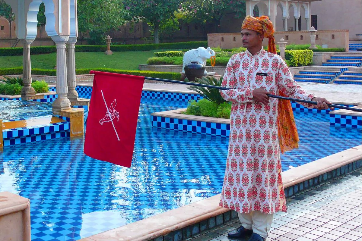 A flag waver at the 5-star Rambagh Palace hotel performs his duty of chasing away birds from the property’s courtyard fountain, in Jaipur, India. (Cindy Drukier/Epoch Times)