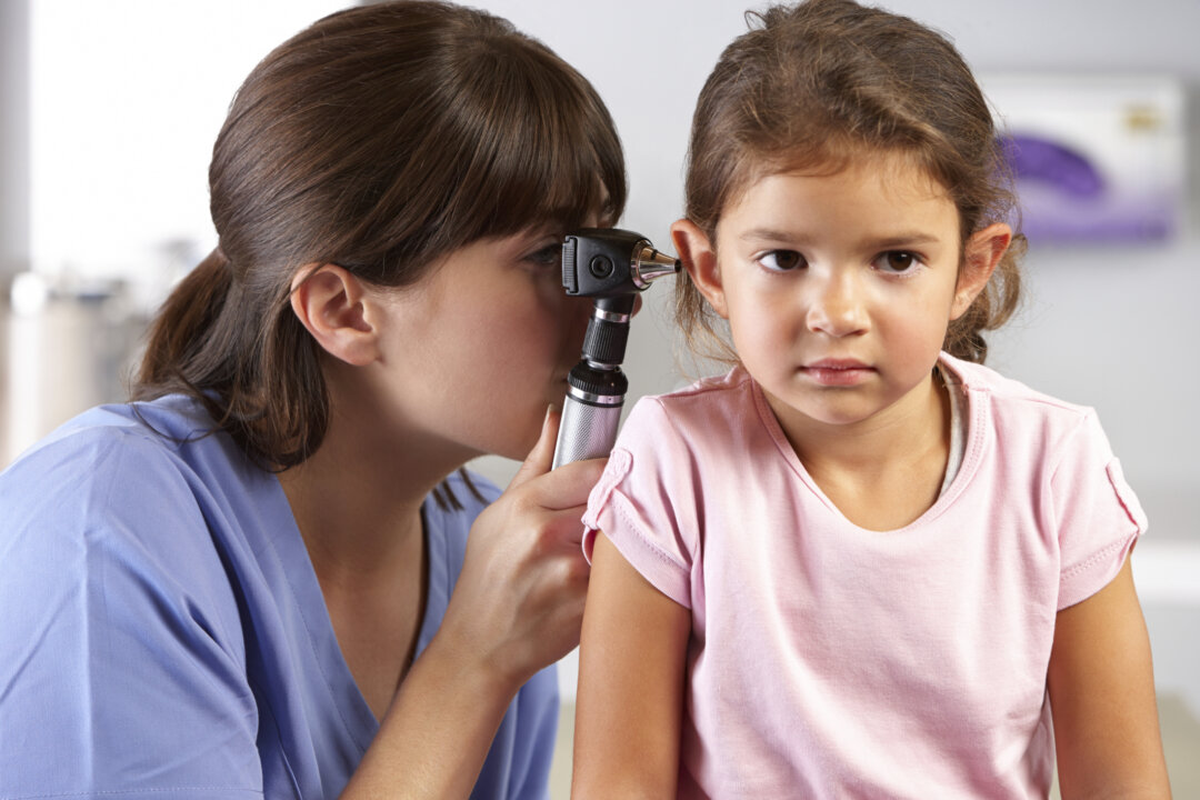 A doctor examines a young girl’s ears. Hearing loss is an issue throughout childhood, with contributing factors that include earphone use with the volume turned up too high, loud urban environments, head trauma through physical sports, and excessive noise from video games, movies, and other media. (Catherine Yeulet/Photos.com)