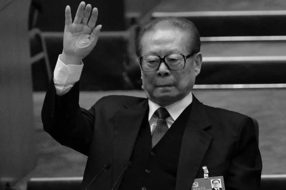 Former Chinese Communist Party head Jiang Zemin raises his hand at the closing of the 18th Communist Party Congress at the Great Hall of the People in Beijing on Nov. 14, 2012. The aged Jiang recently had dinner with former U.S. Secretary of State Henry Kissinger in an effort to shore up his waning influence, writes Xia Xiaoqiang. (Goh Chai Hin/AFP/Getty Images)