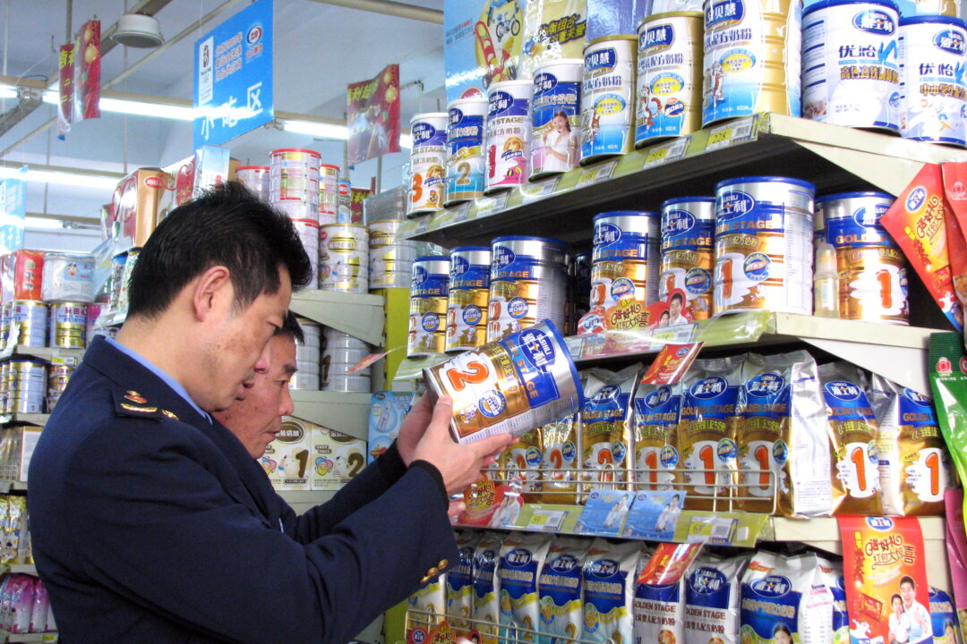 Chinese enforcement officers check the dates on the tins of milk powder at a shop in Tongzi, southwest China's Guizhou region on February 9, 2010, as dairy products containing the industrial chemical melamine have been turning up again in stores. China is hunting for nearly 100 tonnes of tainted milk powder that was supposed to have been destroyed after a 2008 scandal over the deaths of six babies. (AFP/Getty Images)