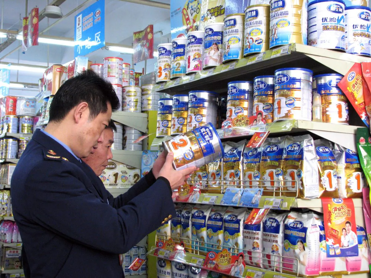 Chinese enforcement officers check the dates on the tins of milk powder at a shop in Tongzi, southwest China's Guizhou region on February 9, 2010, as dairy products containing the industrial chemical melamine have been turning up again in stores. China is hunting for nearly 100 tonnes of tainted milk powder that was supposed to have been destroyed after a 2008 scandal over the deaths of six babies. (AFP/Getty Images)