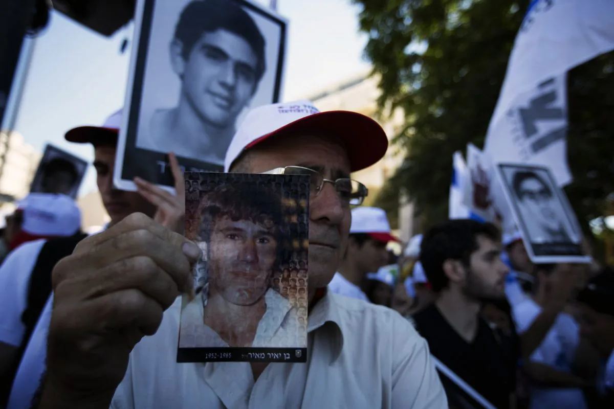 Israelis holding pictures of their loved ones, killed by Palestinians, protest against the planned release of 104 veteran Palestinian and Israeli-Arab prisoners in front of the Prime Minister's office in Jerusalem on July 28, 2013. (Menahem Kahana/AFP/Getty Images)