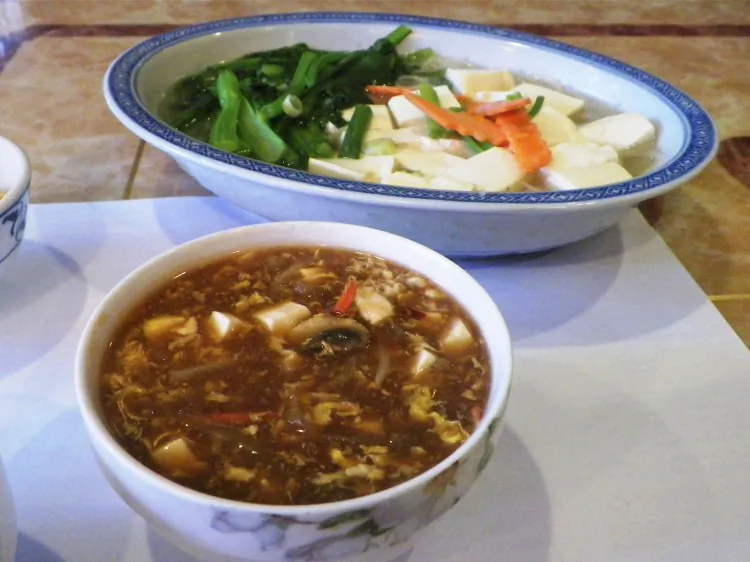 Suan La Tang 酸 辣 湯 (foreground), or hot and sour soup, is a great example of the balance of foods and flavors. This bowl of soup, prepared at the Lucky Dragon in Bennington, Vt., has yang characteristics along with spicy, sour (vinegar), salty (celery) and slightly sweet flavors. (Tanya Harrison/Epoch Times)