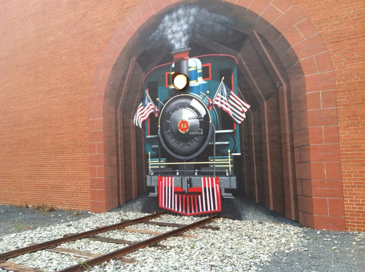 The Train Project mural by Susan Harrell leads to connecting railroad tracks in Asheboro, N.C.. (Denise Darcel/Epoch Times)