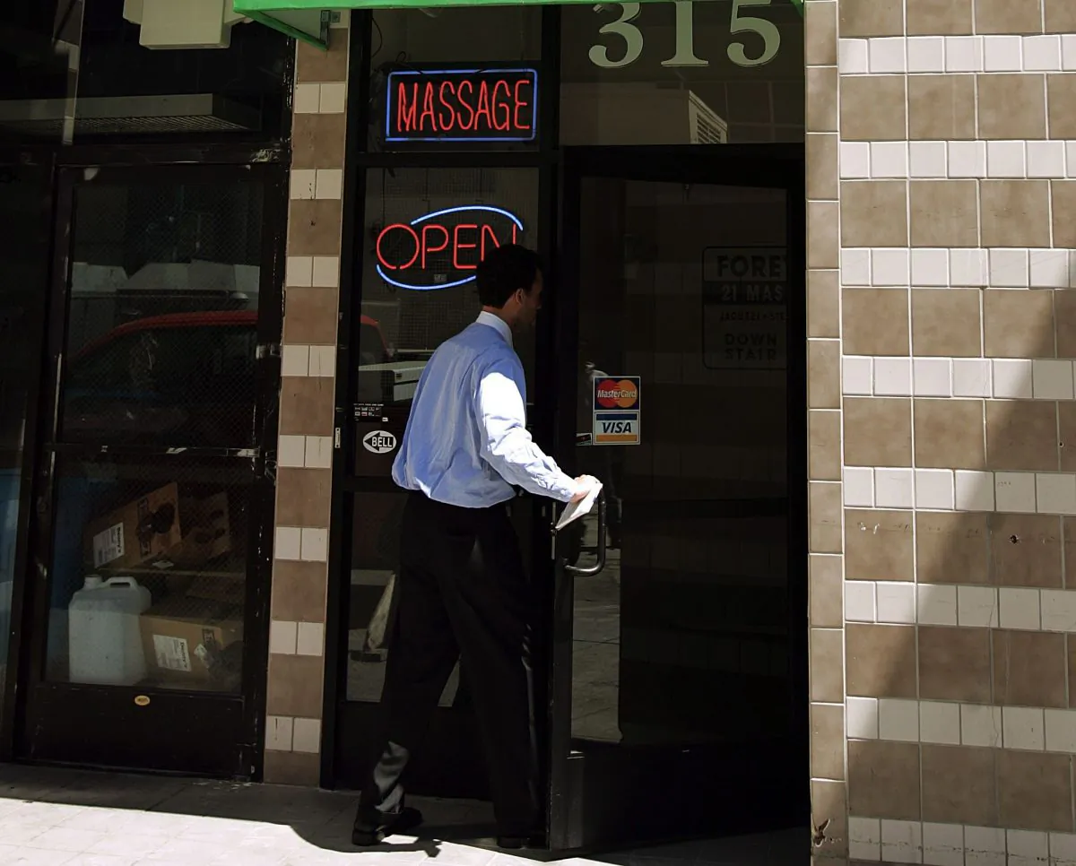 A reporter enters a massage parlor in San Francisco, Calif., July 1, 2005. (AP Photo/Ben Margot)
