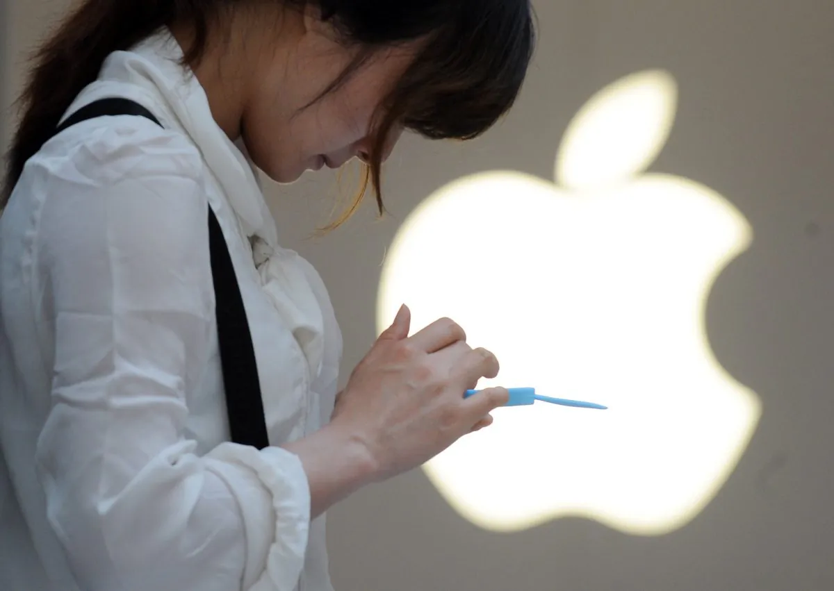 A woman uses her mobile phone outside an Apple store in Shanghai on May 7, 2012. Apple reportedly reached an agreement to sell iPhones through China Mobile, the nation's biggest wireless provider. (Peter Parks/AFP/Getty Images)