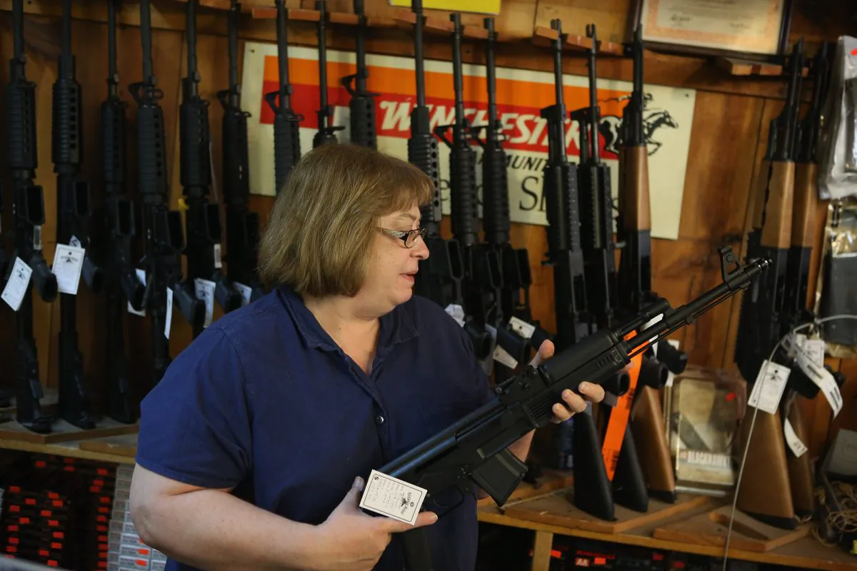Cindy Sparr shows a customer an AK-47 style rifle at Freddie Bear Sports sporting goods store in Tinley Park, Ill., on Dec. 17, 2012. (Scott Olson/Getty Images)