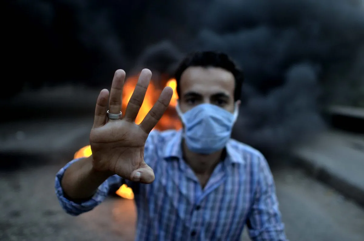 An Egyptian protestor shows his four fingers symbolising the Rabaa al-Adawyia mosque sit-in during clashes between supporters of the Muslim Brotherhood and Egypt's ousted president Mohamed Morsi and security forces, in Cairo, Aug. 30, 2013. Several thousand Egyptians protested in Cairo in support of ousted president Mohamed Morsi, their turnout far lower than hoped for by the harried Islamists who called for mass rallies. AFP PHOTO/MOHAMED EL-SHAHED (Mohamed El-Shahed/AFP/Getty Images)
